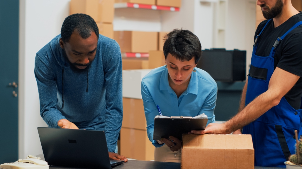 Diverse team of people checking supply chain on warehouse shelves